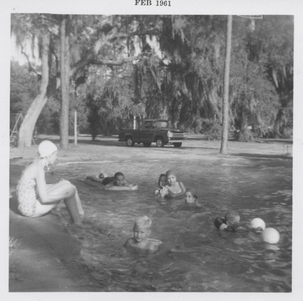 Kids swimming in our pool. My mom was a Brownie Scout leader and she gave them swimming lessons. I'm lying on the float.